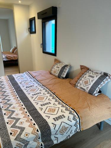 ein Bett mit einer Decke in einem Schlafzimmer in der Unterkunft La Corderie in Mûrs-Érigné