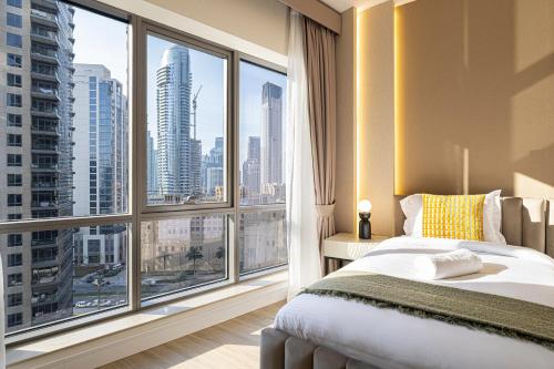 um quarto com uma cama e uma grande janela em Magnificent Mesmerizing 2BR Burj Khalifa View em Dubai