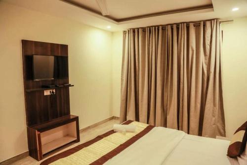 a hotel room with a bed and a television at Laxmi Stay Hotel in New Delhi