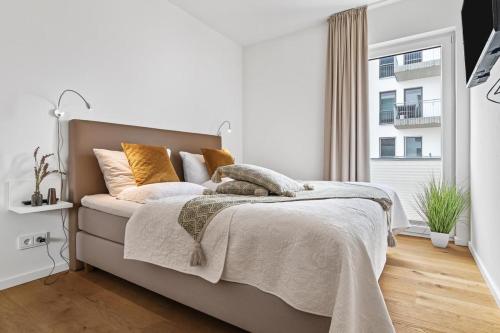 um quarto branco com uma cama e uma janela em Ocean Heart- 1OG, Balkon, Kamin em Olpenitz