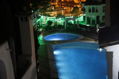 a view of two swimming pools at night at Apartamento En Pueblo Evita Con Piscina Y Terraza in Benalmadena Costa