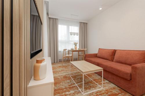 a living room with a couch and a table at Sun & Beach Apartments Bel Mare with Parking by Noclegi Renters in Międzyzdroje