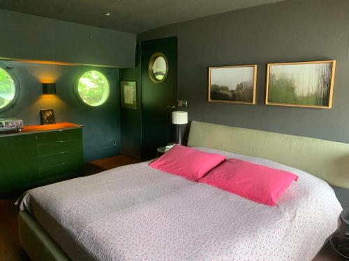 a bedroom with a pink bed and two windows at Péniche Suresnes in Suresnes