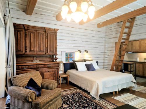 1 dormitorio con 1 cama y 1 silla en una habitación en Kenama Loghouse and Archaic Sauna, en Meremõisa