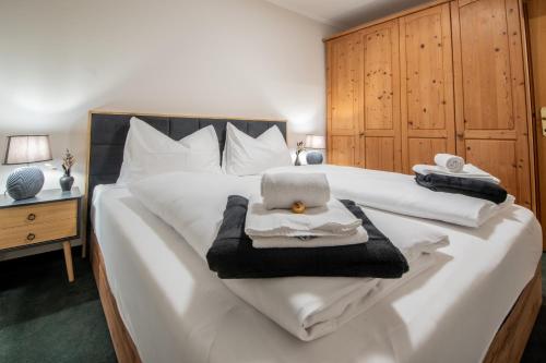 a bedroom with a white bed with a laptop on it at Bergblick Appartements in Bad Gastein
