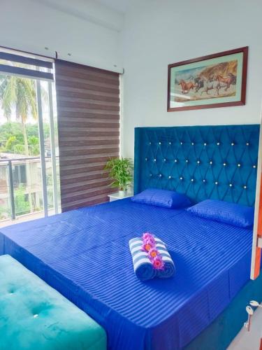 a blue bed with two pairs of shoes on it at ORA Luxury Villas Hikkaduwa in Hikkaduwa