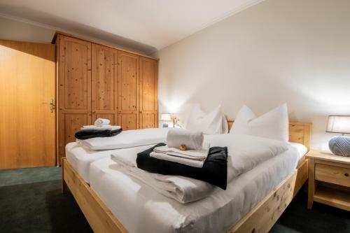 a bedroom with a large white bed with towels on it at Bergblick Appartements in Bad Gastein