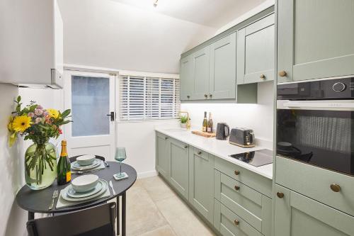 a kitchen with a table with a vase of flowers at Host & Stay - Bentley Wynd in Yarm
