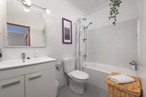 a white bathroom with a toilet and a sink at Sunset apartment Es Celler in Alcudia