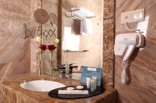un bagno dell'hotel con lavandino e telefono di فندق قصر توبال للشقق المخدومة a Gedda