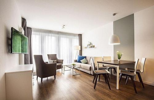 Una sala de estar con una mesa y un comedor. en Ferienwohnung 1-24 im Deichhaus 1, en Wohlendorf