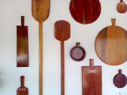 a bunch of wooden spatulas hanging on a wall at Gunam Residence in Kattankudi
