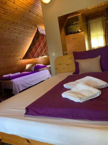 a bedroom with two beds with purple and white sheets at Sashalom Hotel in Budapest