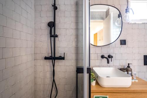 W łazience znajduje się prysznic, umywalka i lustro. w obiekcie Akicity Campolide Amber w Lizbonie