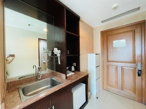 a kitchen with a sink and a wooden door at Superior Room At Galeri Ciumbuleuit 1st Tower with Best View in Bandung