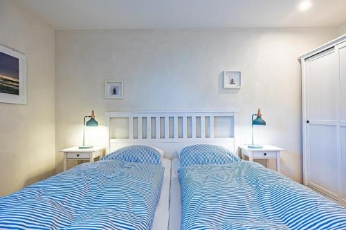 a bedroom with two beds and two tables with lamps at Ferienwohnung Luv in Gelting