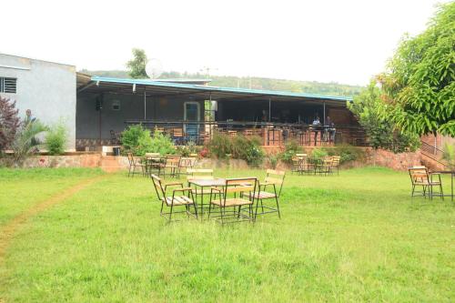 eine Gruppe von Tischen und Stühlen in einem Hof in der Unterkunft Bwiza Cool Palace in Kabuga