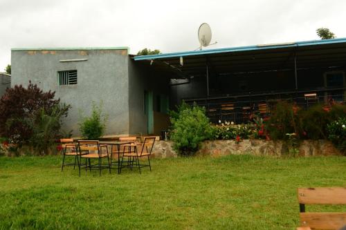 einen Tisch und Stühle vor einem Gebäude in der Unterkunft Bwiza Cool Palace in Kabuga