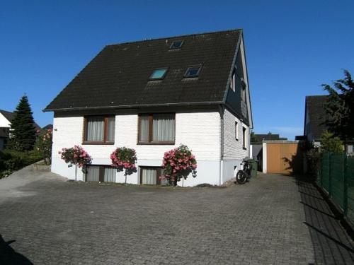 a large white house with flowers in front of it at Ferienwohnung Wöllner Nr 1 in Maasholm