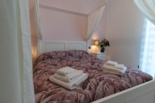 a bedroom with a bed with towels on it at Villa Roberta in Mandello del Lario