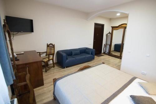 a room with a bed and a couch and a table at Hotel Villa Natali in Chişinău