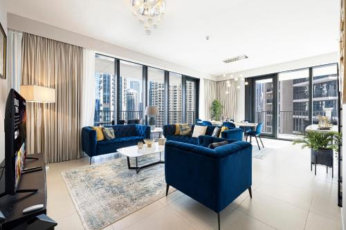 a living room with blue furniture and large windows at Magnificent Cozy 2BR in Downtown Dubai in Dubai