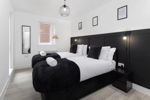Orange Rentals- Apartment close to Anfield- sleeps 6 guests- Free Parking! في ليفربول: غرفة نوم مع سرير كبير مع سريرين