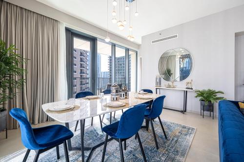 a dining room with a table and blue chairs at Magnificent Cozy 2BR in Downtown Dubai in Dubai