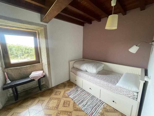 a small bedroom with a bed and a window at Grupo Gontad A Vixia do Roncudo in A Coruña