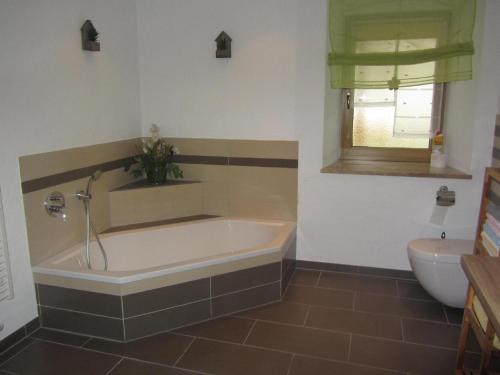 a bathroom with a tub and a toilet at Gästehaus Meier Ferienwohnung und Camping in Eschlkam