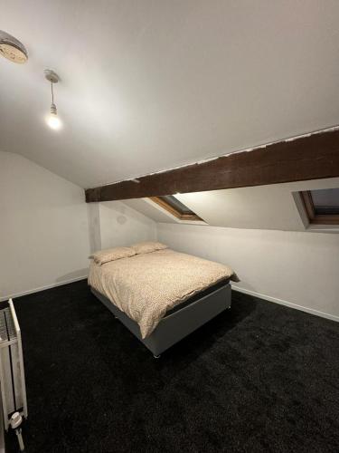 ein Schlafzimmer mit einem Bett in einem Zimmer in der Unterkunft Victor's House in Huddersfield