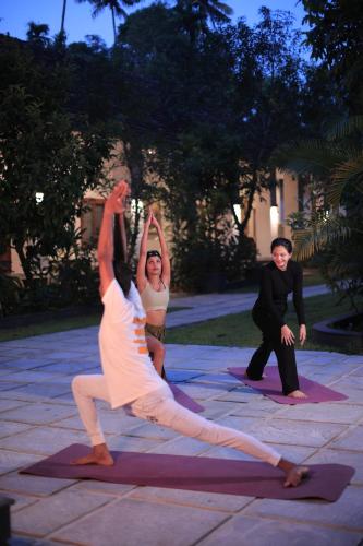 a group of people doing yoga in a courtyard at Softouch Ayurveda Village Kerala in Kizhake Chālakudi