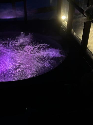 a purple bath tub in a dark room at Ragnar Glamp Pitrags Lux in Pitragutsiyeme