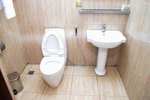 a bathroom with a toilet and a sink at Golden Tulip Hotel -GT31 Stadium Road in Port Harcourt