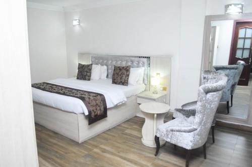 Habitación de hotel con cama y silla en Golden Tulip Hotel -GT31 Stadium Road, en Port Harcourt