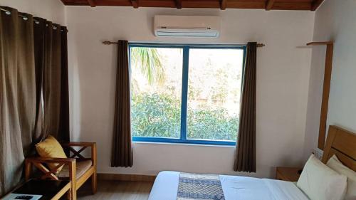 a bedroom with a bed and a large window at BENTO CORBETT WOODS RESORT in Jhirna