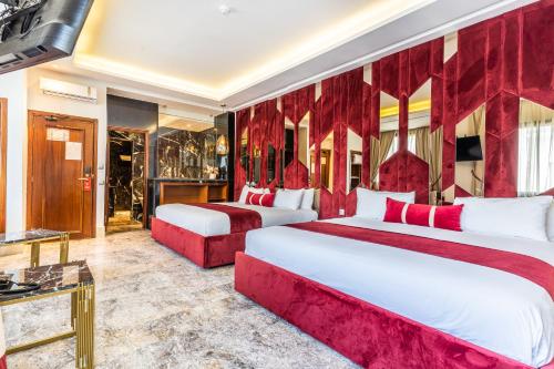 2 letti in una camera con tende rosse di One Hotel Casablanca a Casablanca