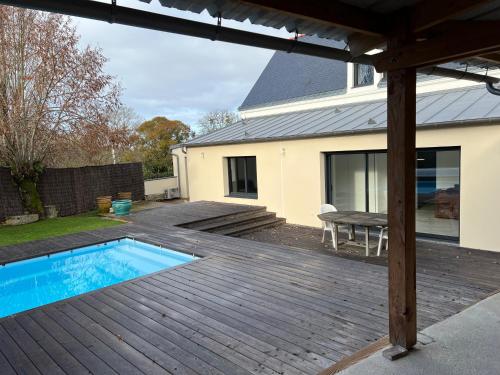 un patio avec une piscine et une terrasse en bois dans l'établissement La Corderie, à Mûrs-Érigné