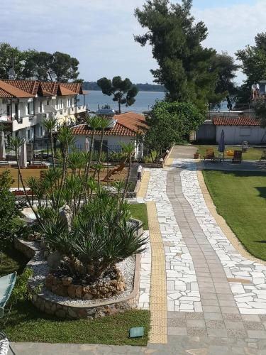 a garden with a walkway with plants in a yard at Makis Nest Apart-Hotel in Vourvourou