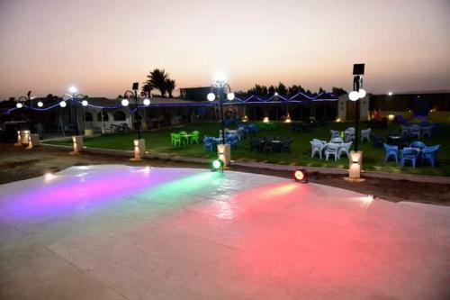 a pool with colored lights in a yard at night at ايركرافت للسياحه العلاجيه Aircraft for Medical Tourism And Investment 