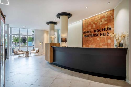 a lobby with a reception desk in a building at Hotel Bochum Wattenscheid affiliated by Meliá in Bochum