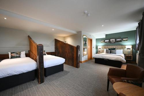 um quarto de hotel com duas camas e um sofá em Crewe & Harpur, Derby by Marston's Inns em Derby