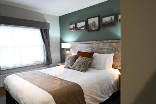 a bedroom with a bed with pillows and a window at Crewe & Harpur, Derby by Marston's Inns in Derby