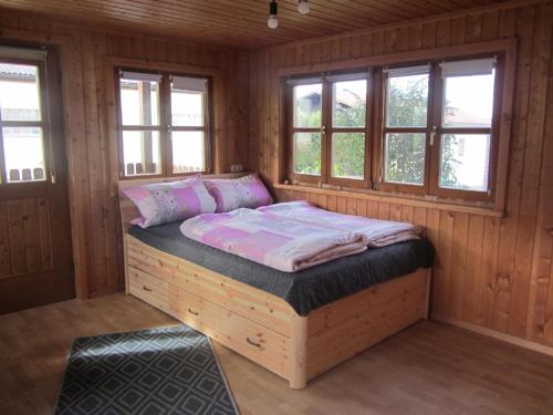 uma cama num quarto de madeira com janelas em Gästehaus Meier Ferienwohnung und Camping em Eschlkam