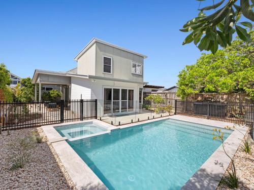 a swimming pool in front of a house at The Beachside Sanctuary -500m from Beach with Pool & Heated Spa in Casuarina