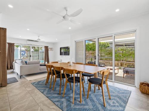 a dining room and living room with a table and chairs at The Beachside Sanctuary -500m from Beach with Pool & Heated Spa in Casuarina