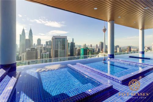 a swimming pool on top of a building with a city skyline at The Luxe & Colony, KLCC in Kuala Lumpur