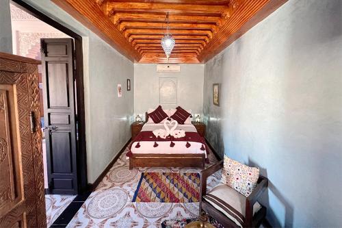 a bedroom with a bed and a chair in it at Dar Ben Saleh in Marrakesh