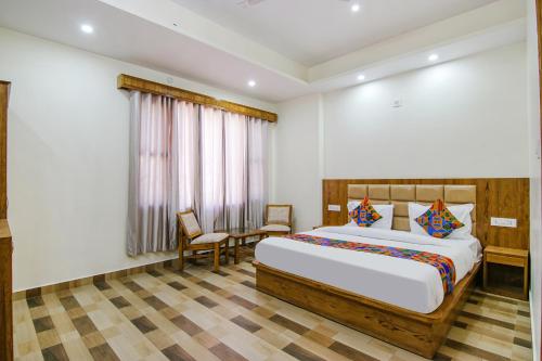 um quarto com uma cama, uma mesa e cadeiras em FabHotel Himalayan Park em Bajaura
