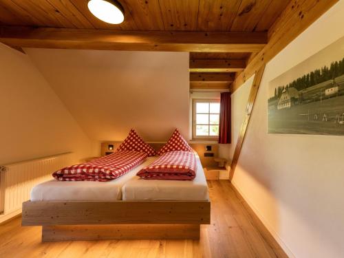 1 dormitorio con 2 camas y almohadas rojas en Holzhof en Breitnau